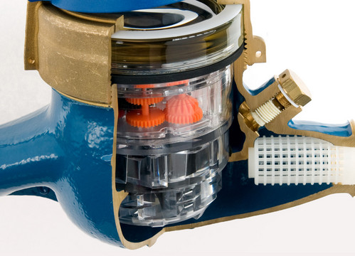 Ein blauer Wasserzähler ist an einer Seite offen, so dass man die darin verbauten Einzelteile und Materialien sieht.
