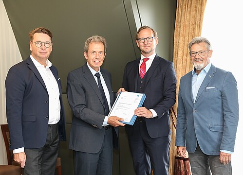 Vertreter der ASUE und des DVGW halten den unterschriebenen Vertrag in Berlin in die Kamera