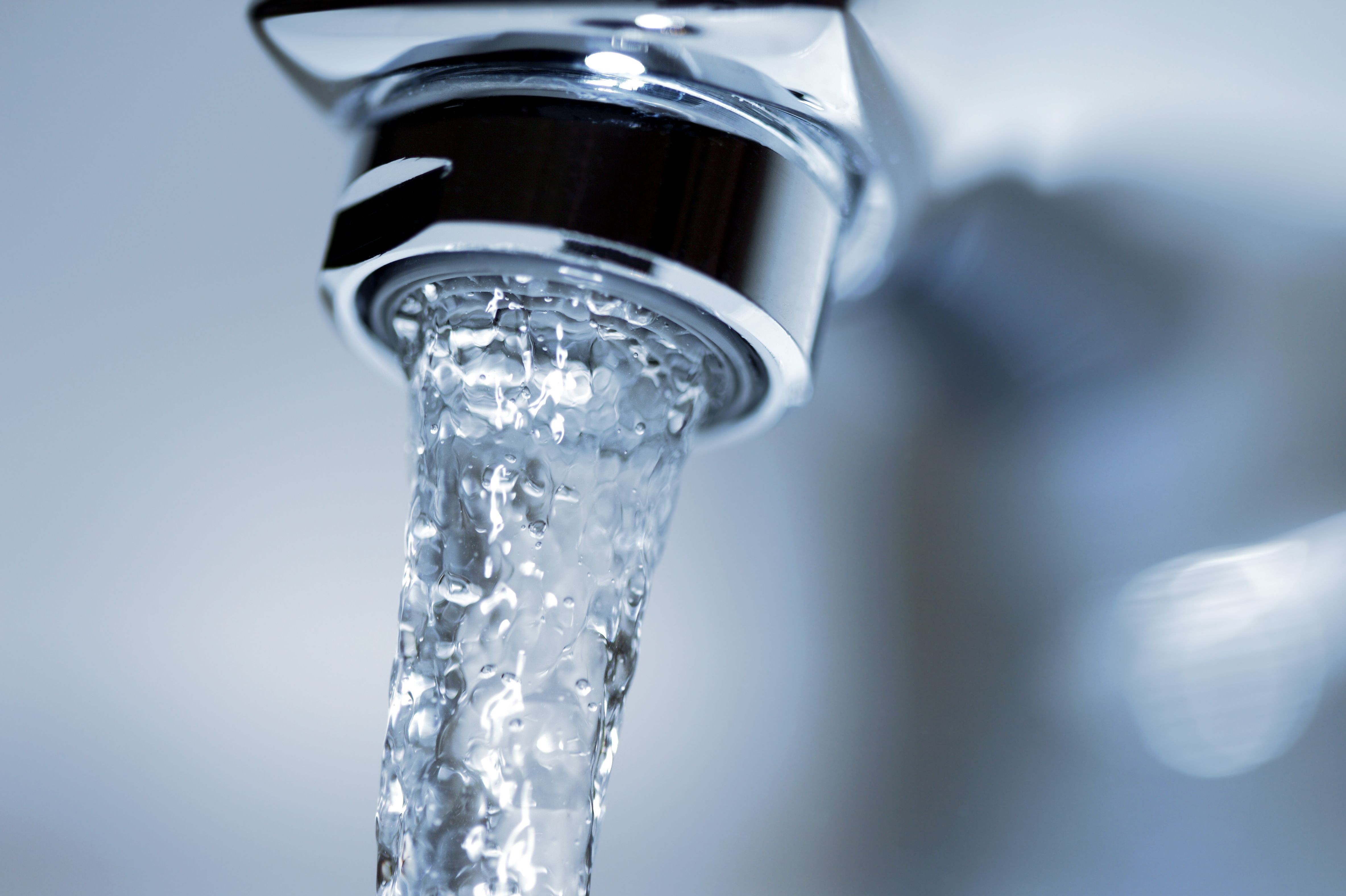 Wasserhahn mit Strahlregler, aus dem ein Wasserstrahl läuft