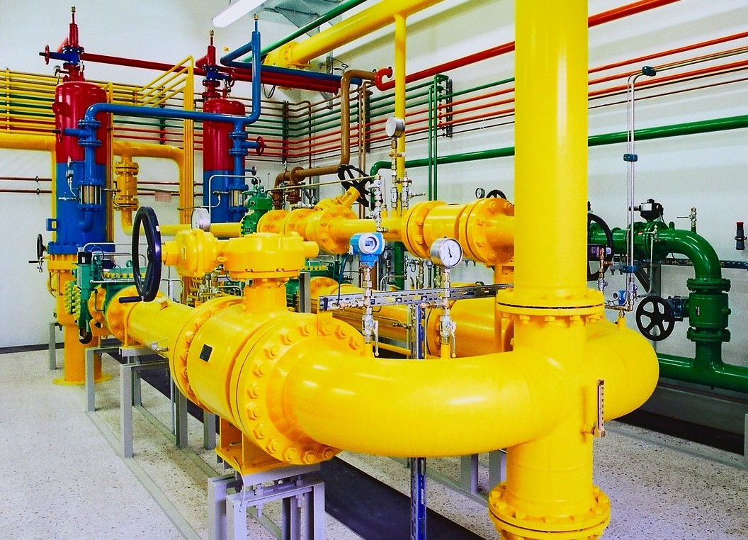 Verschiedenfarbige Rohrleitungen mit Verschraubungen in einer Gasdruck-Regelanlage