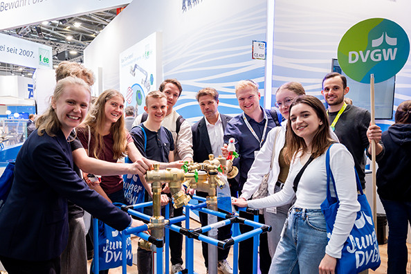 Alle Gruppenmitglieder greifen nach einer Installation von Wasserarmaturen