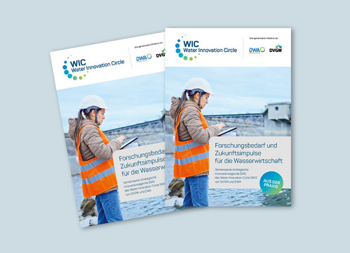 Junge Frau mit Helm und in Warnweste arbeitet an einer Talsperre mit einem Tablet