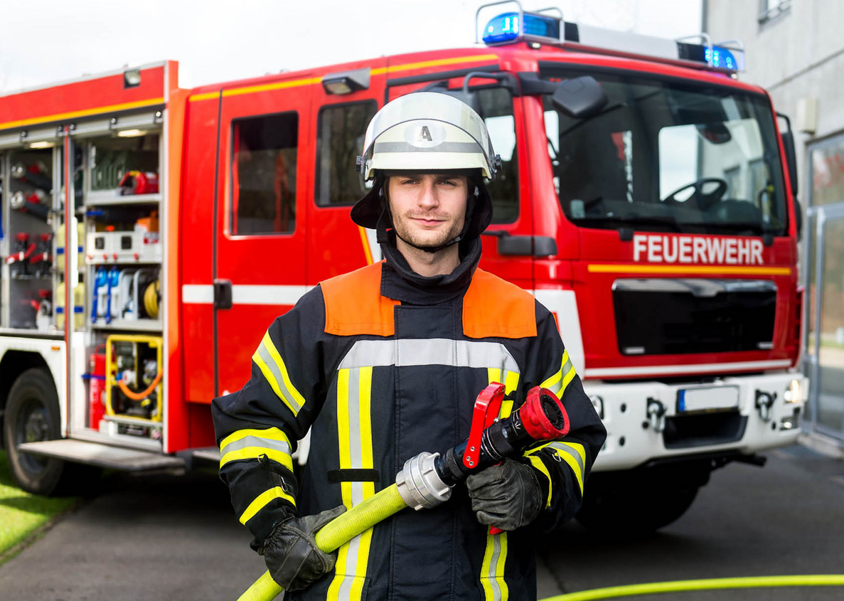 Feuerwehrmann vor Einsatzfahrzeug