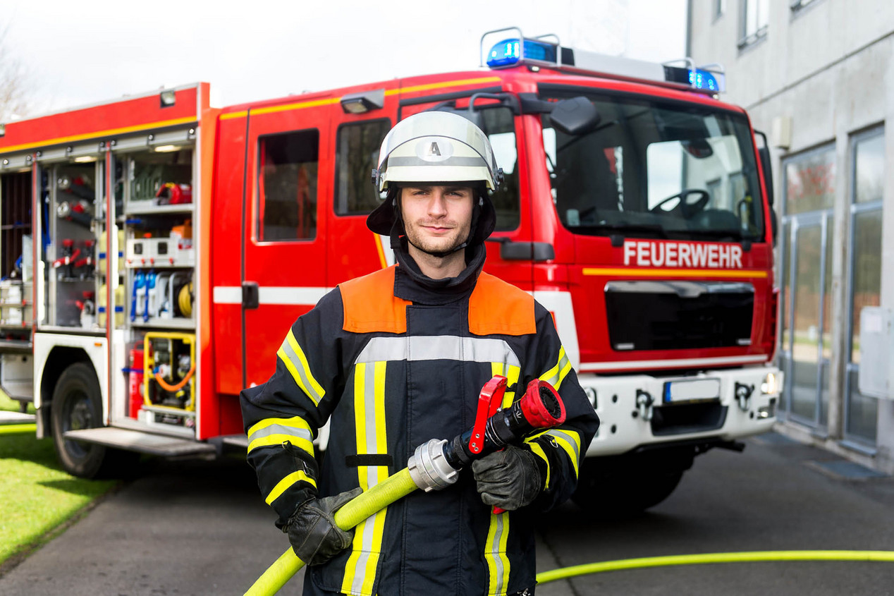 Feuerwehrmann vor Einsatzfahrzeug