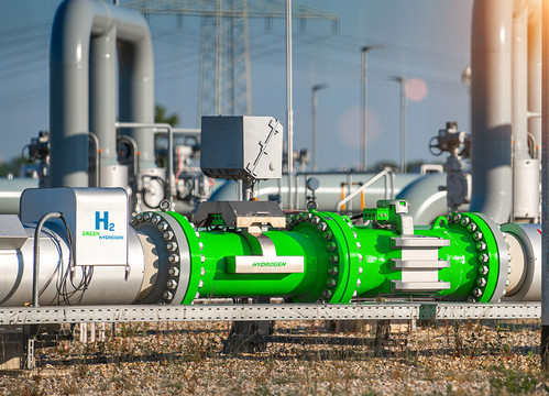 Ein mächtiges, im Freien liegendes, teils silbernes, teils grünes Rohr mit "H2"-Aufschrift