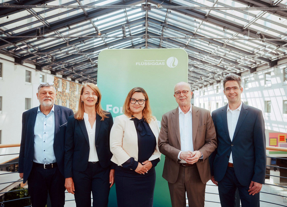 Zwei Frauen und drei Männer stehen in einer Halle unter dem Logo des Deutschen Verbandes Flüssiggas