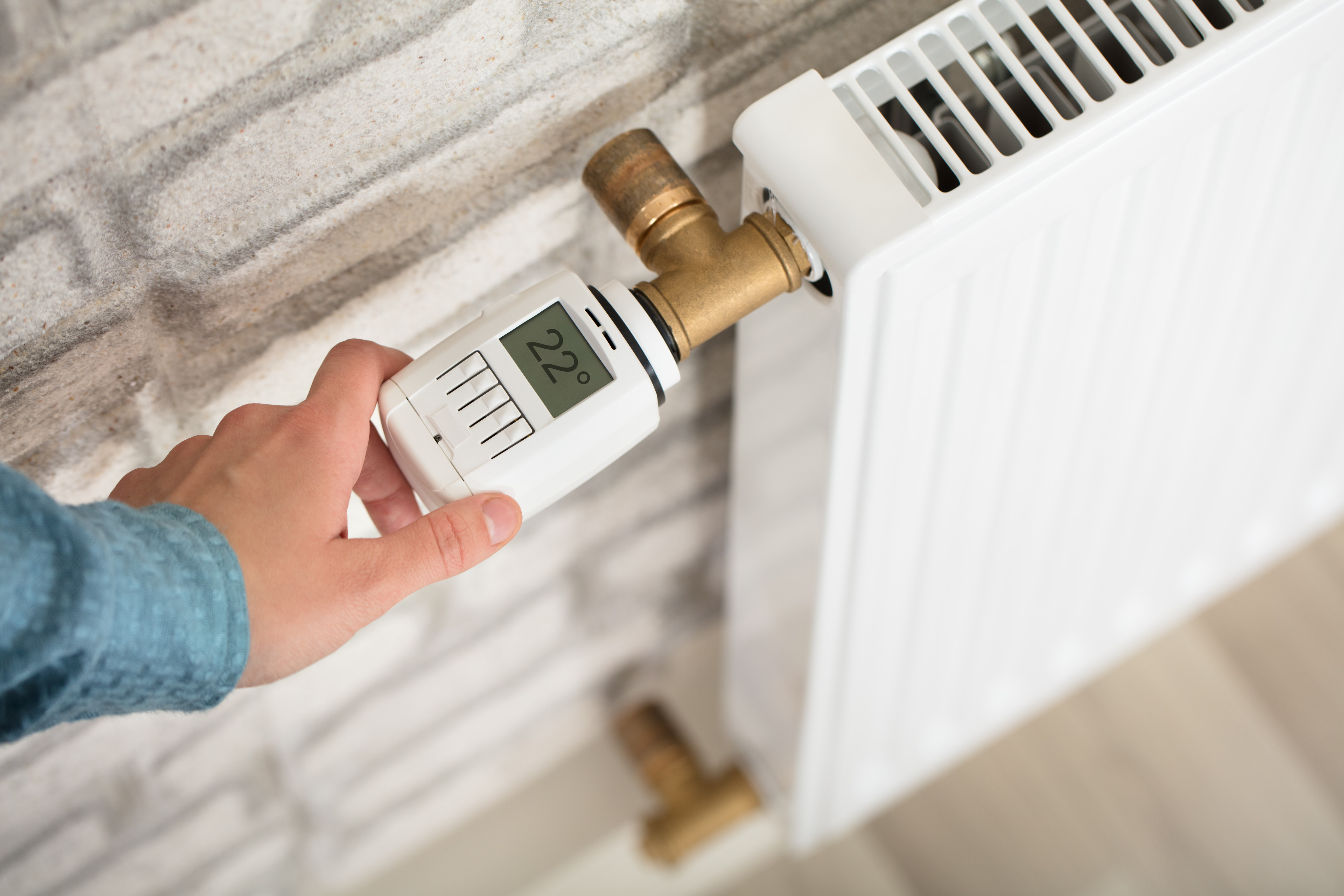 Person Adjusting Temperature On Thermostat