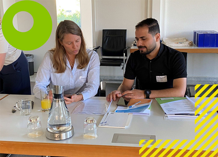 Eine Mentorin und ein Mentee sitzen am Tisch und besprechen sich