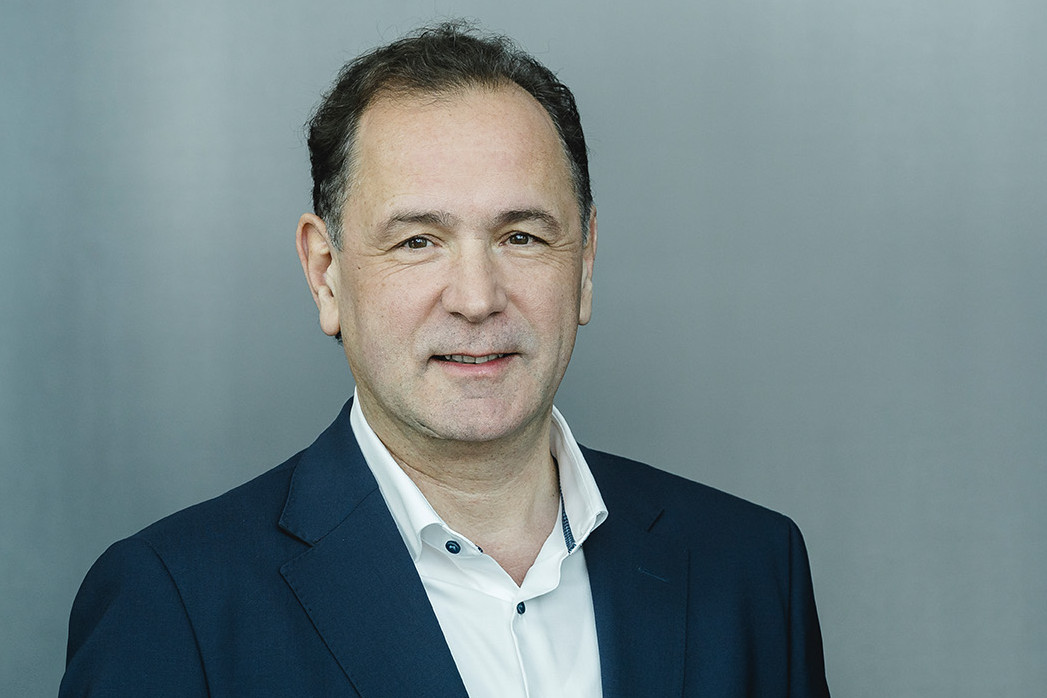 Brustbild von Prof. Dr. Gerald Linke im blauen Anzug mit weißen Hemd vor 