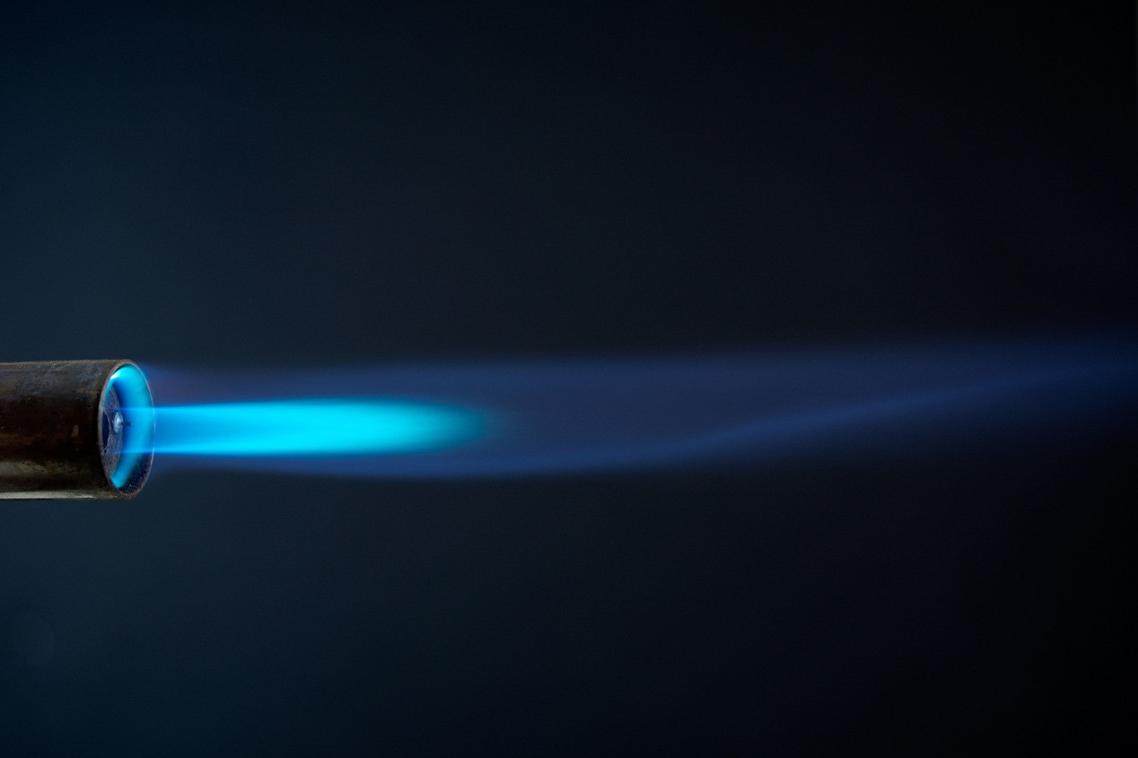 Schwarzes Bild mit blauer Brennerflamme mit Methan und Wasserstoff