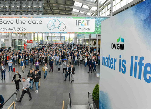Blick in der Totalen auf den Eingang der Messe München anlässlich der dortigen IFAT. Rechts unter dem DVGW-Logo steht das Motto "Water is Life".