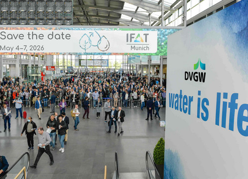 Blick in der Totalen auf den Eingang der Messe München anlässlich der dortigen IFAT. Rechts unter dem DVGW-Logo steht das Motto "Water is Life".