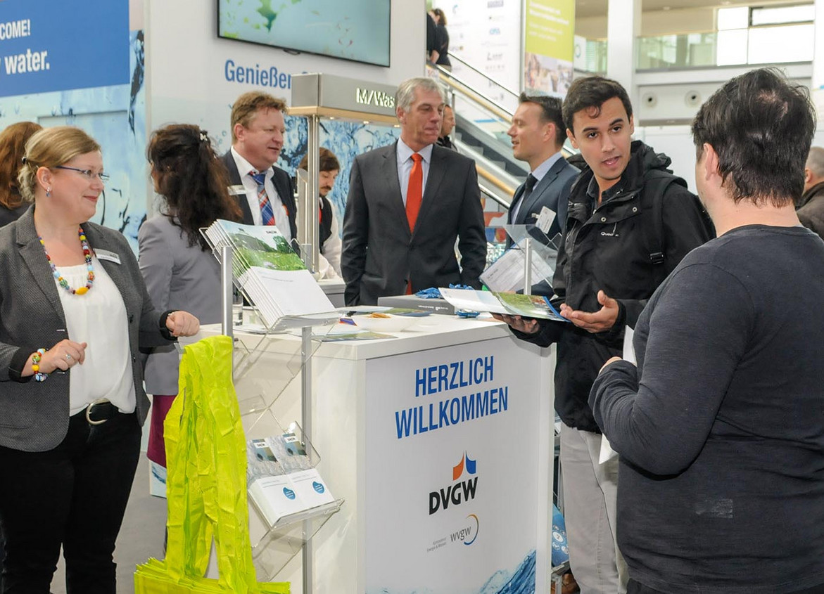 Besucher und DVGW-Mitarbeitende stehen am DVGW-Stand 2018 auf der IFAT