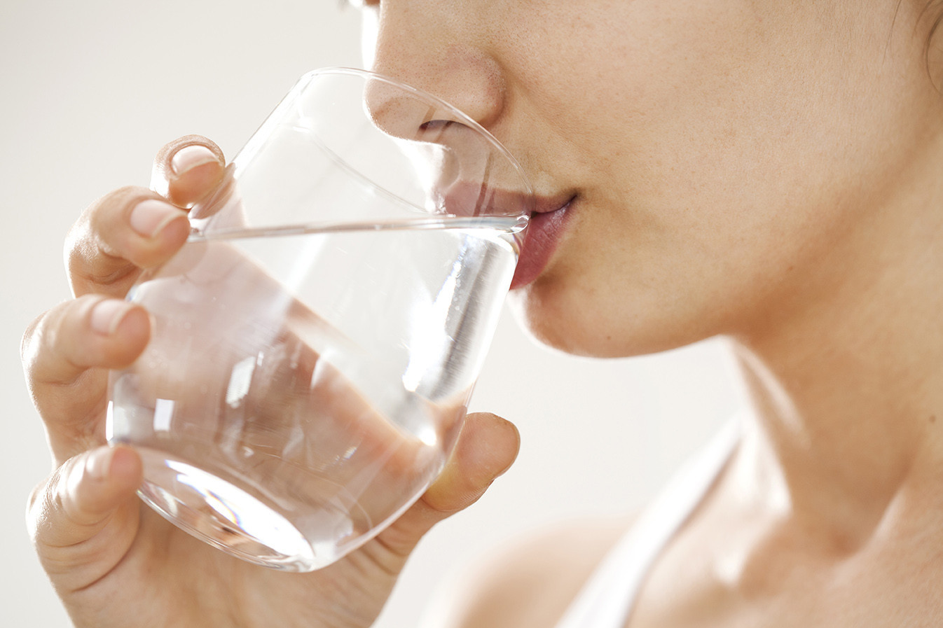 Frau trinkt aus einem Wasserglas