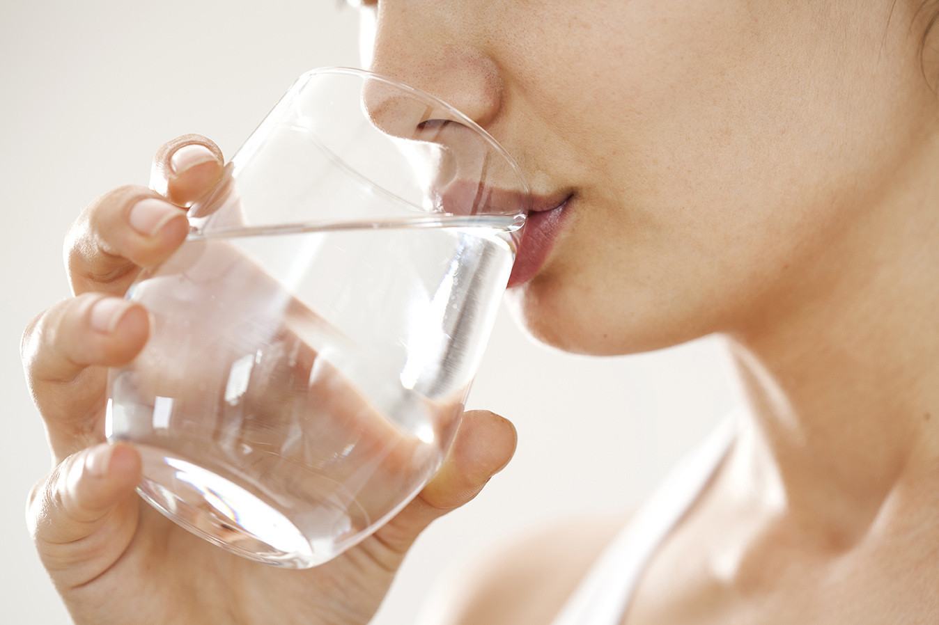 Frau trinkt aus einem Wasserglas