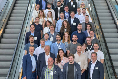Auf einer Rolltreppe stehen die rund 60 Gründungsmitglieder des Jungen DVGW zusammen mit dem Vorstand und dem Präsidenten des DVGW e.V.